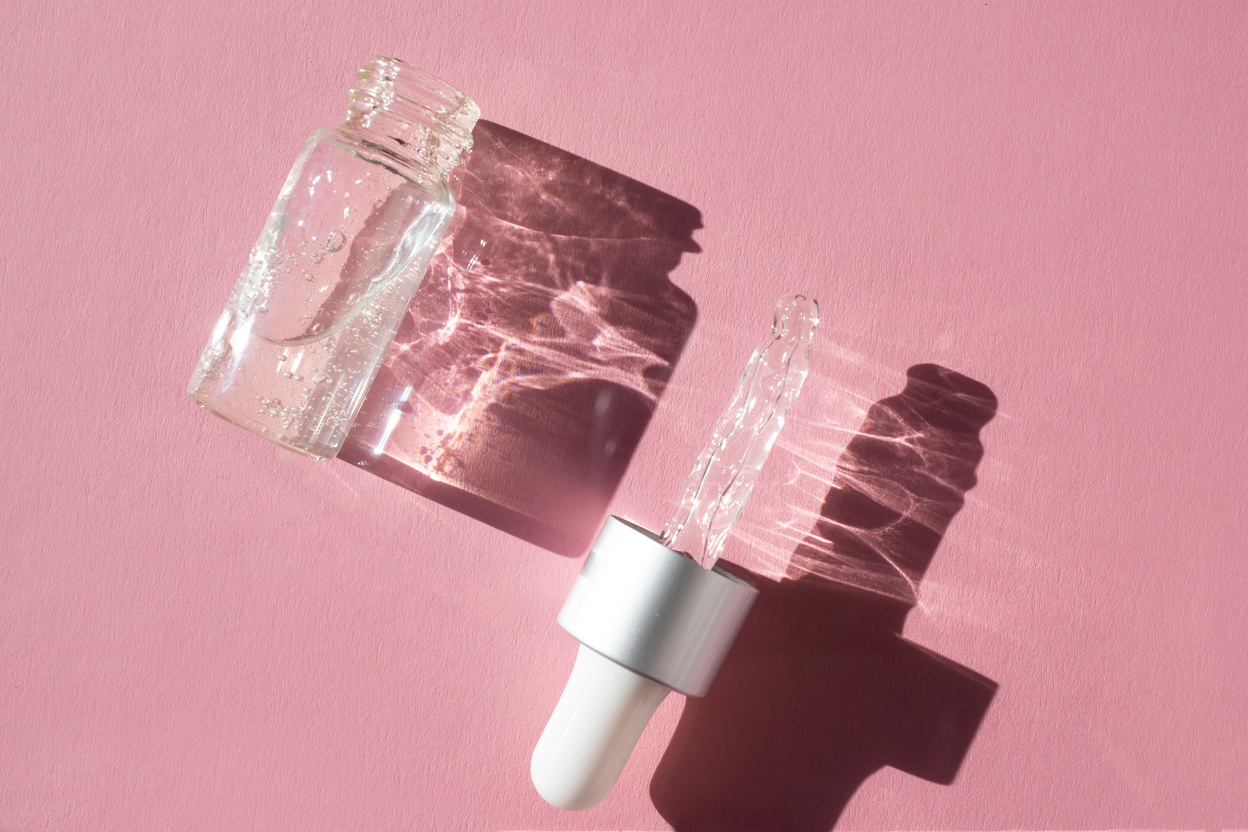 Glass Dropper Bottles with Serum on a Pink Background