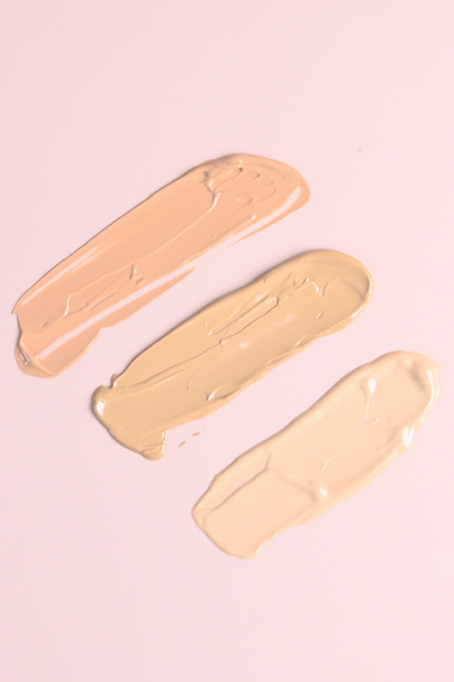 Makeup foundation smears on pink background. BB, CC cream foundation tonal smudge